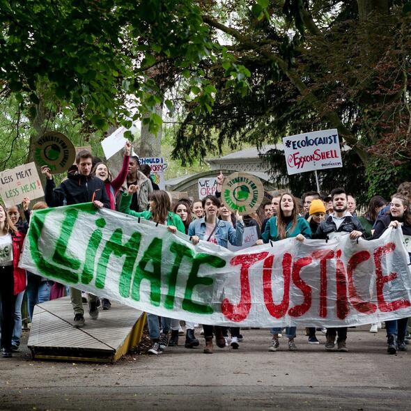 Een groep jongeren met een klimaatprotest vlag